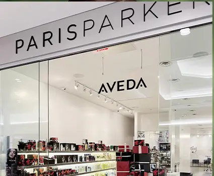 - Paris Parker Aveda Salons and Spas - Baton Rouge, New Orleans, Mandeville, LA A glass storefront displays the names Paris Parker and Aveda; inside the hair salon, shelves are stocked with beauty and hair care products, including balayage essentials. - Paris Parker Aveda Salons and Spas - Baton Rouge, New Orleans, Mandeville, LA