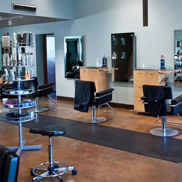 - Paris Parker Aveda Salons and Spas - Baton Rouge, New Orleans, Mandeville, LA A modern Aveda Salon with empty styling chairs, mirrors, and shelves stocked with hair products. The floor is clean, the space is well-lit—perfect for balayage or a relaxing facial. - Paris Parker Aveda Salons and Spas - Baton Rouge, New Orleans, Mandeville, LA