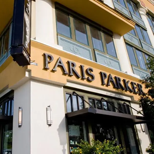 - Paris Parker Aveda Salons and Spas - Baton Rouge, New Orleans, Mandeville, LA The exterior of an Aveda Salon building featuring large windows and a sign reading "Paris Parker" above the entrance, inviting guests in for a luxurious haircut or expert balayage services. - Paris Parker Aveda Salons and Spas - Baton Rouge, New Orleans, Mandeville, LA