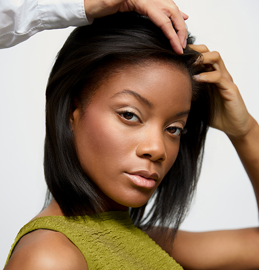 - Paris Parker Aveda Salons and Spas - Baton Rouge, New Orleans, Mandeville, LA A woman with straight shoulder-length hair and a green top looks at the camera while someone at an Aveda Salon arranges her hair. - Paris Parker Aveda Salons and Spas - Baton Rouge, New Orleans, Mandeville, LA