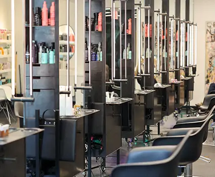 - Paris Parker Aveda Salons and Spas - Baton Rouge, New Orleans, Mandeville, LA A row of empty Aveda Salon chairs and workstations with hair products, mirrors, and tools neatly arranged, ready for your next haircut or facial in this modern hair salon. - Paris Parker Aveda Salons and Spas - Baton Rouge, New Orleans, Mandeville, LA