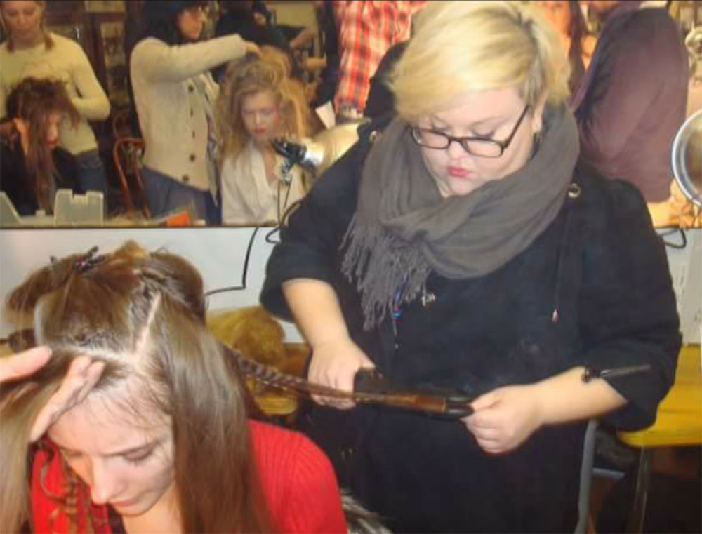 - Paris Parker Aveda Salons and Spas - Baton Rouge, New Orleans, Mandeville, LA A hairstylist braids a woman's hair in a busy hair salon, while other hairdressers work on clients in the background, creating an atmosphere similar to a vibrant day spa. - Paris Parker Aveda Salons and Spas - Baton Rouge, New Orleans, Mandeville, LA
