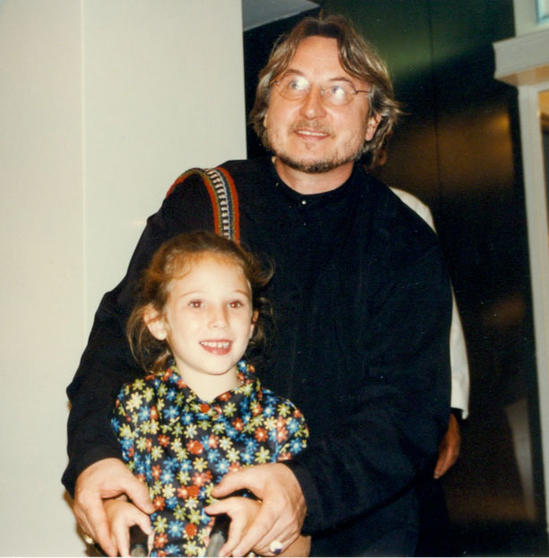 - Paris Parker Aveda Salons and Spas - Baton Rouge, New Orleans, Mandeville, LA An adult man stands behind a young girl, holding her hands. Both are looking slightly off-camera and smiling. The background appears to be indoors, possibly at a hair salon where they just enjoyed a balayage treatment. - Paris Parker Aveda Salons and Spas - Baton Rouge, New Orleans, Mandeville, LA