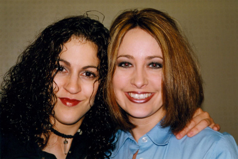 - Paris Parker Aveda Salons and Spas - Baton Rouge, New Orleans, Mandeville, LA Two women posing closely together and smiling at the camera, one with curly dark hair and the other with straight light brown hair, show off their glowing facial results in front of a plain background. - Paris Parker Aveda Salons and Spas - Baton Rouge, New Orleans, Mandeville, LA