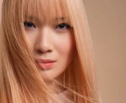 - Paris Parker Aveda Salons and Spas - Baton Rouge, New Orleans, Mandeville, LA A woman with long, straight, light blonde hair and bangs shows off her fresh haircut as she looks at the camera against a neutral background. - Paris Parker Aveda Salons and Spas - Baton Rouge, New Orleans, Mandeville, LA