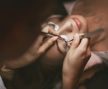 - Paris Parker Aveda Salons and Spas - Baton Rouge, New Orleans, Mandeville, LA At an Aveda Salon and Day Spa, a technician applies individual eyelash extensions with tweezers while the client relaxes with eyes closed and protective pads under their eyes. - Paris Parker Aveda Salons and Spas - Baton Rouge, New Orleans, Mandeville, LA
