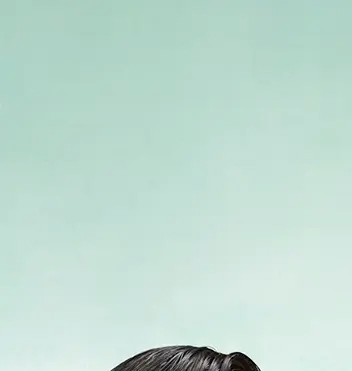- Paris Parker Aveda Salons and Spas - Baton Rouge, New Orleans, Mandeville, LA The top portion of a person's head with dark hair is visible against a plain light green background, showcasing a fresh balayage from a trendy hair salon. - Paris Parker Aveda Salons and Spas - Baton Rouge, New Orleans, Mandeville, LA