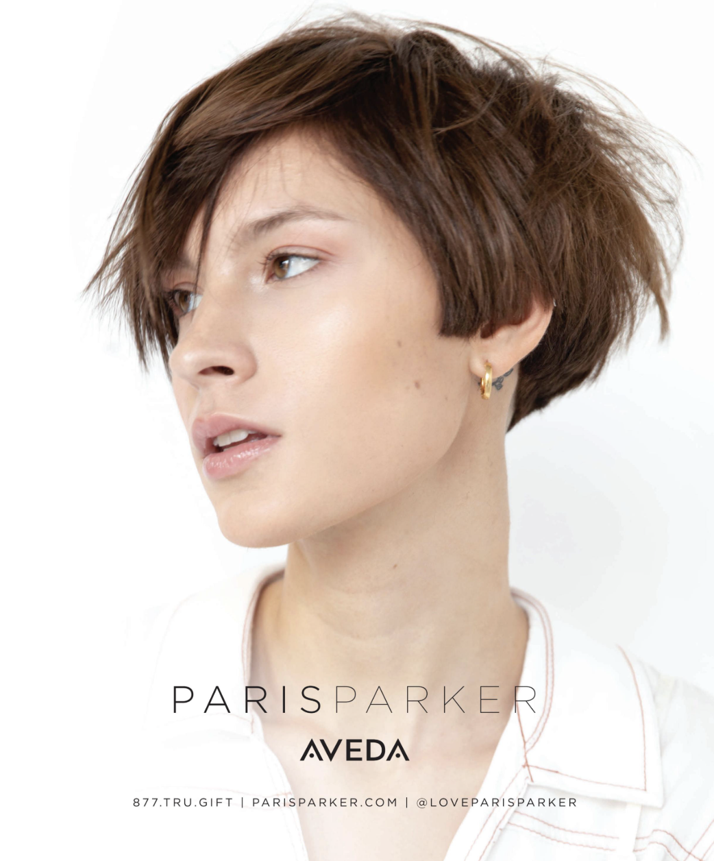 - Paris Parker Aveda Salons and Spas - Baton Rouge, New Orleans, Mandeville, LA Person with short brown hair and a gold hoop earring looks to the side, channeling the latest trends; Paris Parker Aveda branding and contact details are at the bottom, reminiscent of an inRegister GLOW lookbook. - Paris Parker Aveda Salons and Spas - Baton Rouge, New Orleans, Mandeville, LA